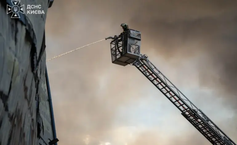 Firefighters extinguish a fire at a building in Kyiv following a Russian attack