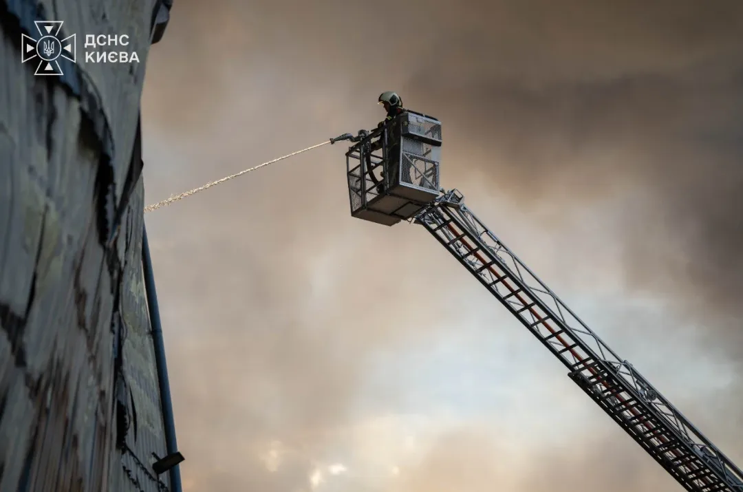 Firefighters extinguish a fire at a building in Kyiv following a Russian attack